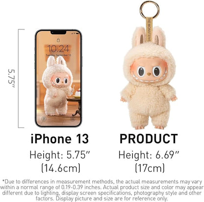 Cream‑colored Labubu blind‑box keychain from POP MART’s “Tasty Macarons” series, standing approximately 17 cm tall—visually compared next to an iPhone 13 for scale—featuring plush bunny‑ears onesie, glossy vinyl face with wide eyes and toothy grin, and attached gold-tone metal ring.”
