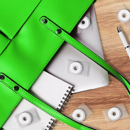 "Life Savers Wint-O-Green Mints spilled on white paper with green bag on a wooden table."